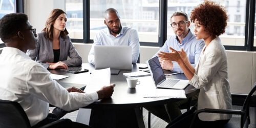 people sitting around a table in an office talking